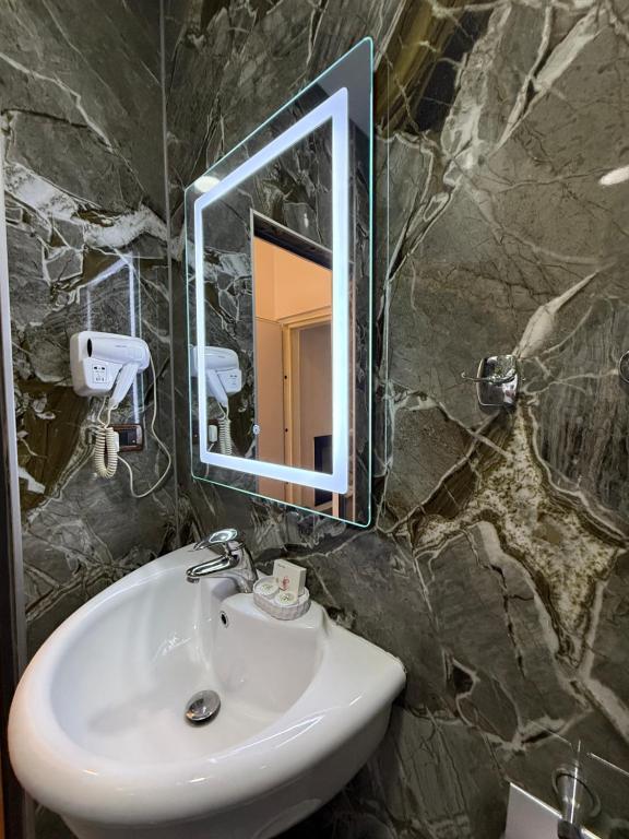 Dark green marble bathroom with rectangular lit mirror