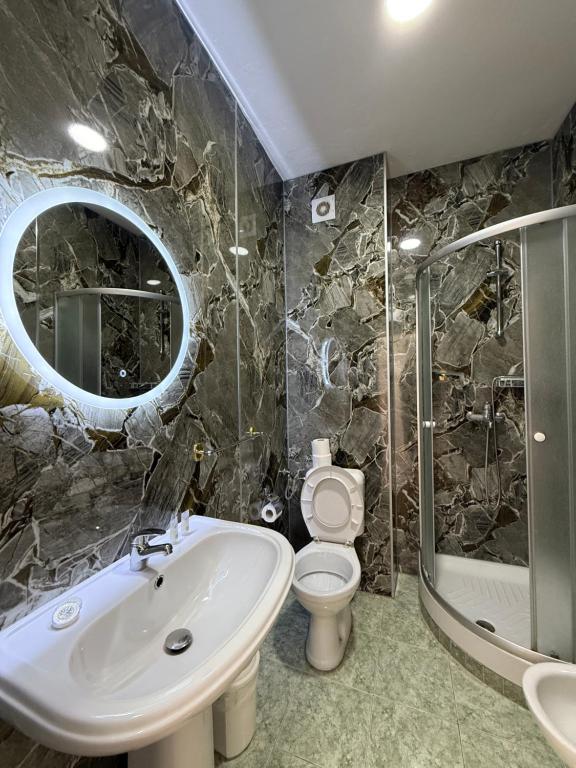 Dark marble bathroom with round backlit mirror