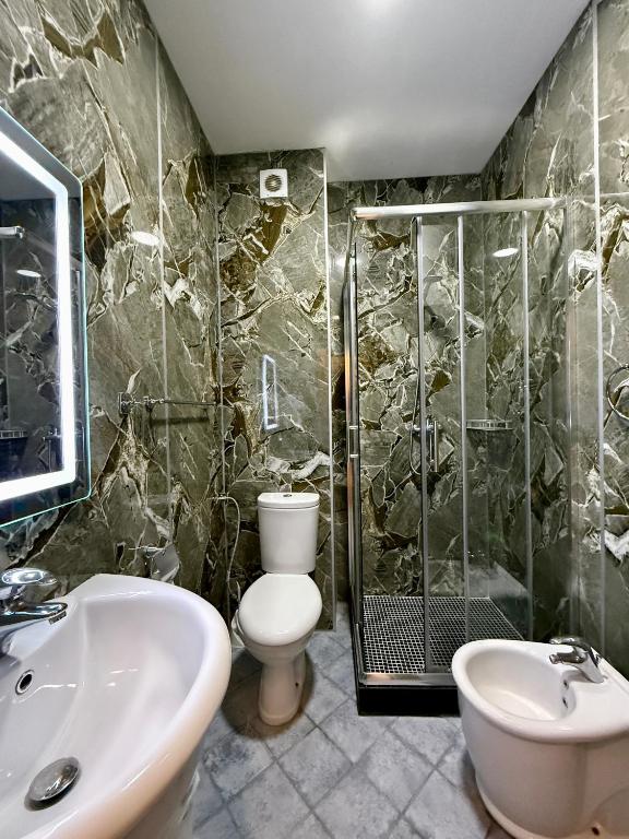 Green marble bathroom with shower and twin basins