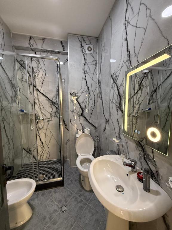 Grey marble bathroom with lit rectangular mirror