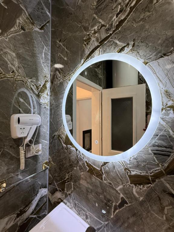 Round backlit mirror against grey-green marble