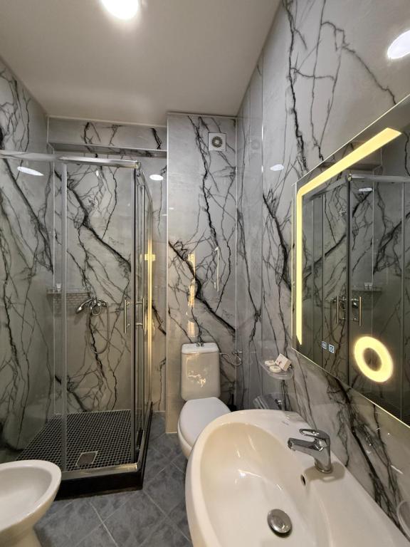 Heavily veined white marble bathroom with walk-in shower