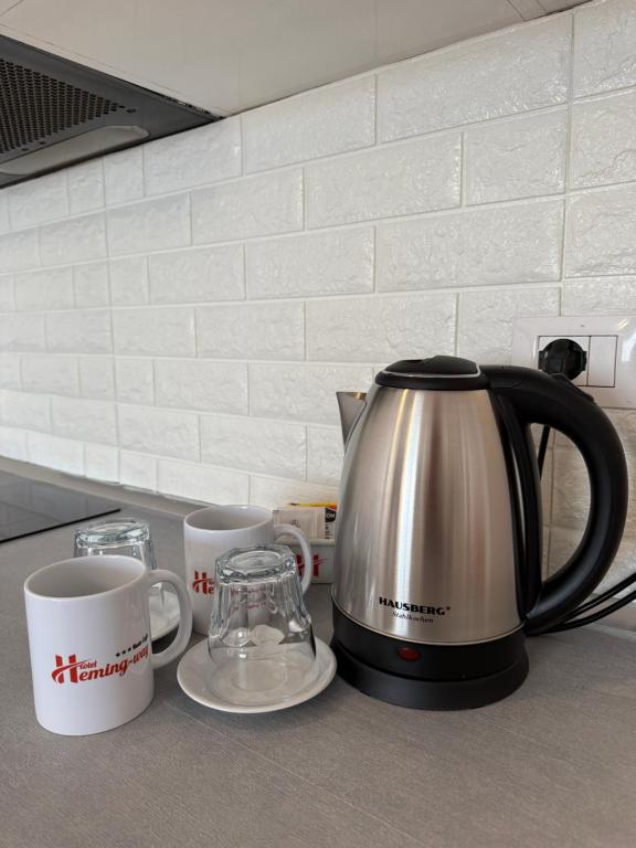 Branded Hotel Heming-uej mug beside the in-room kettle