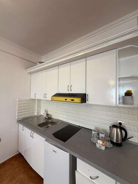 Compact in-suite kitchenette with white cabinets